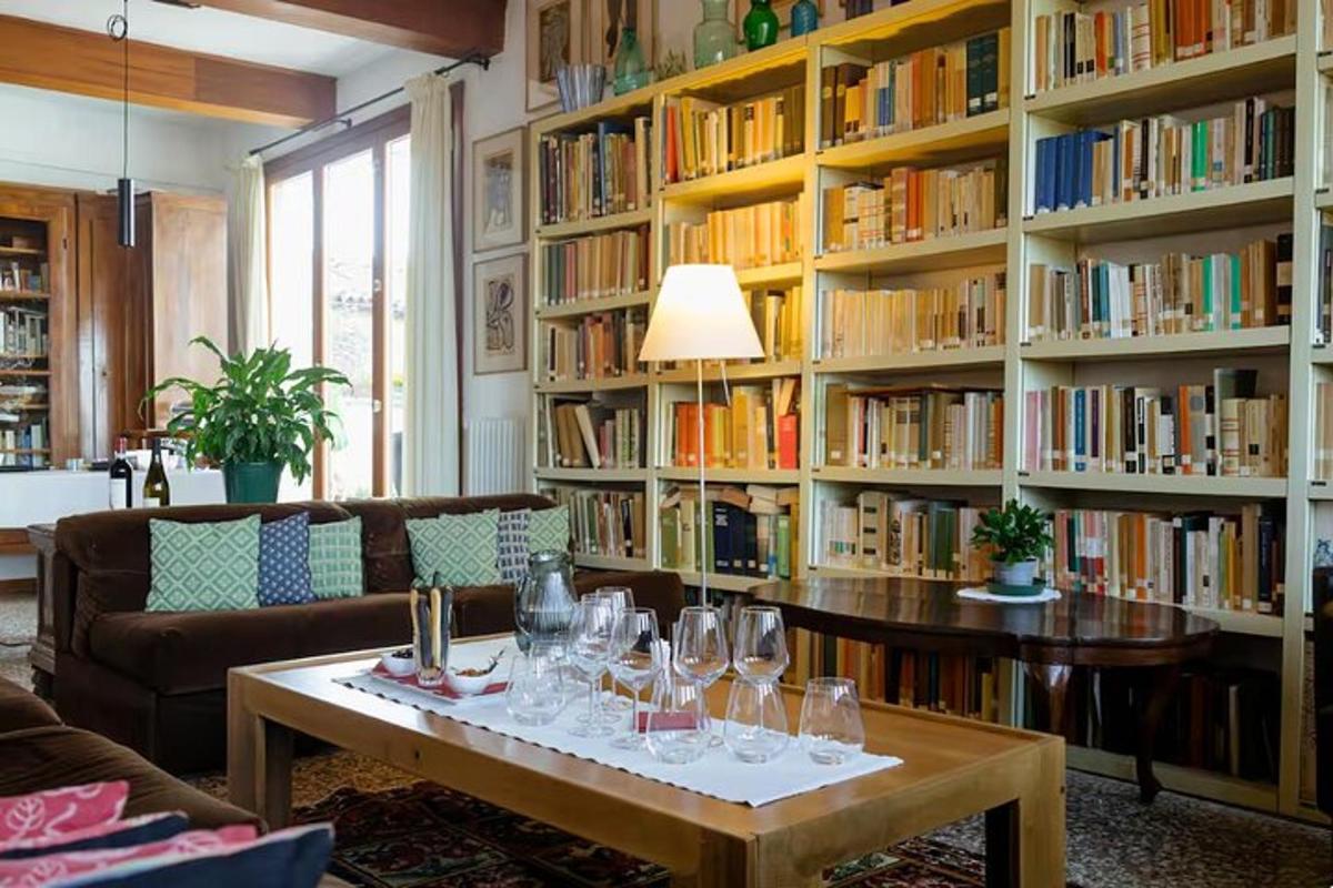Una biblioteca con una mesa con copas de vino encima.