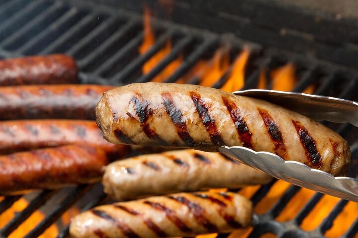 ein Haufen Würstchen und Hot Dogs auf einem Grill