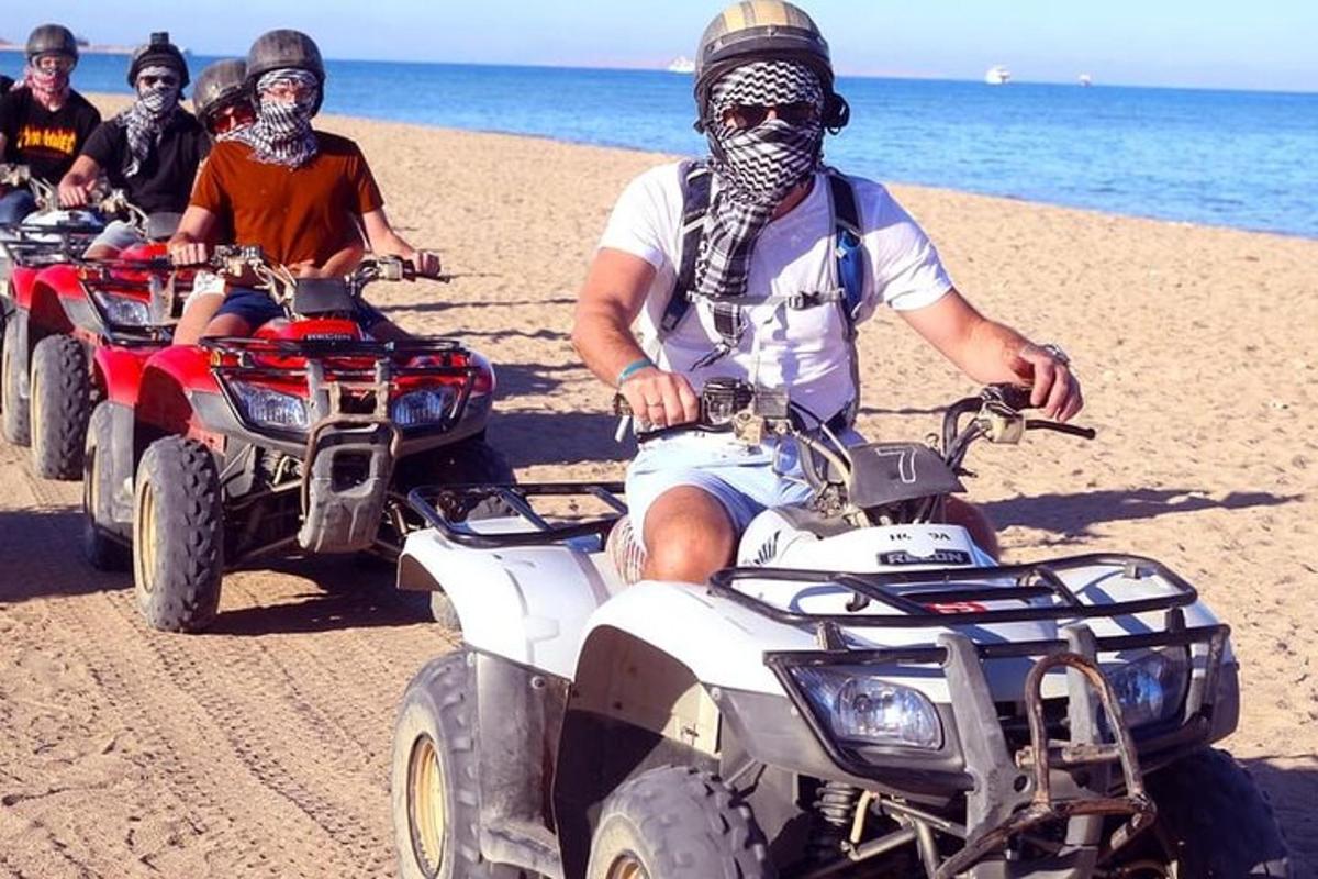 a group of people riding atvs on the beach
