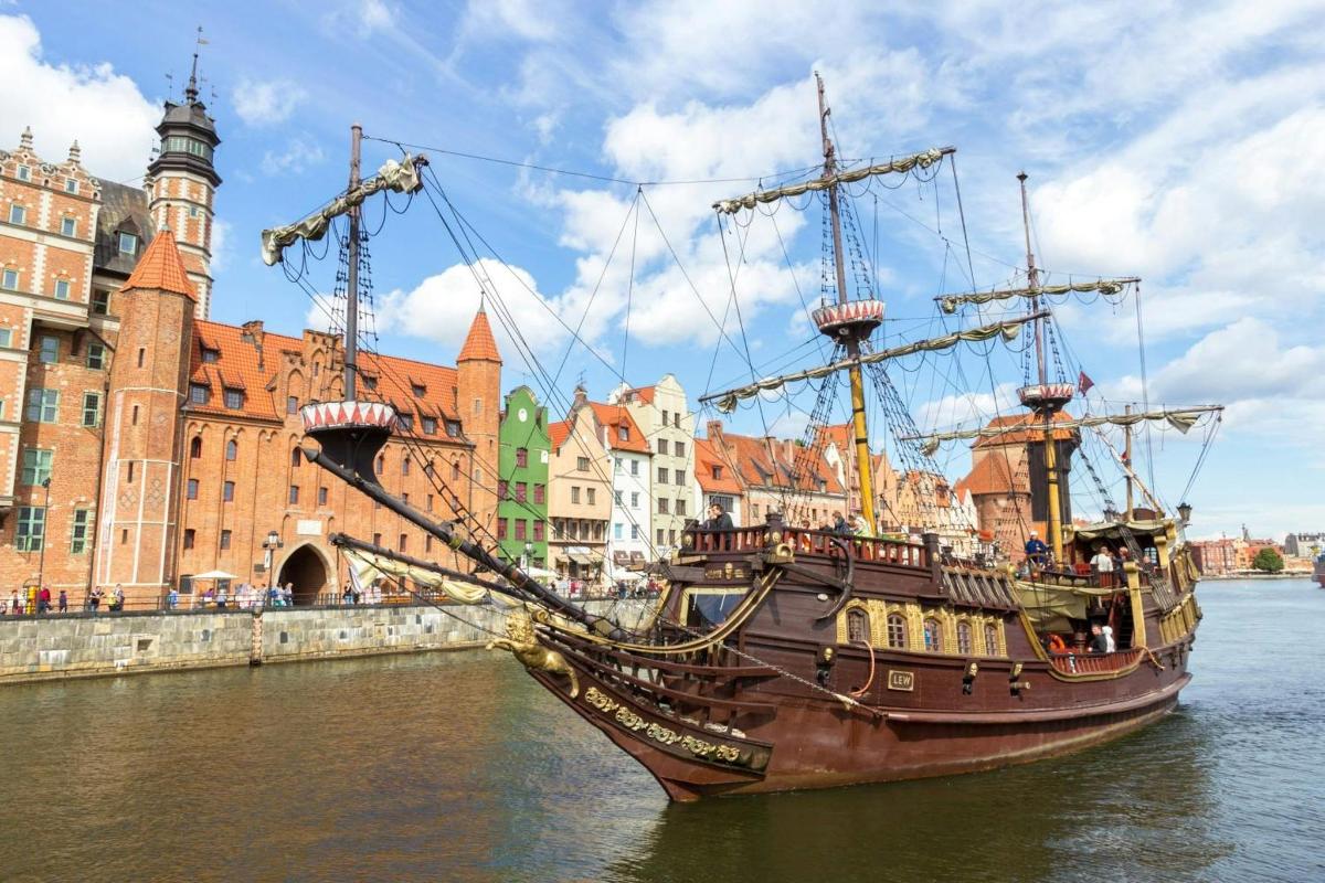 a pirate ship in the water in front of a city