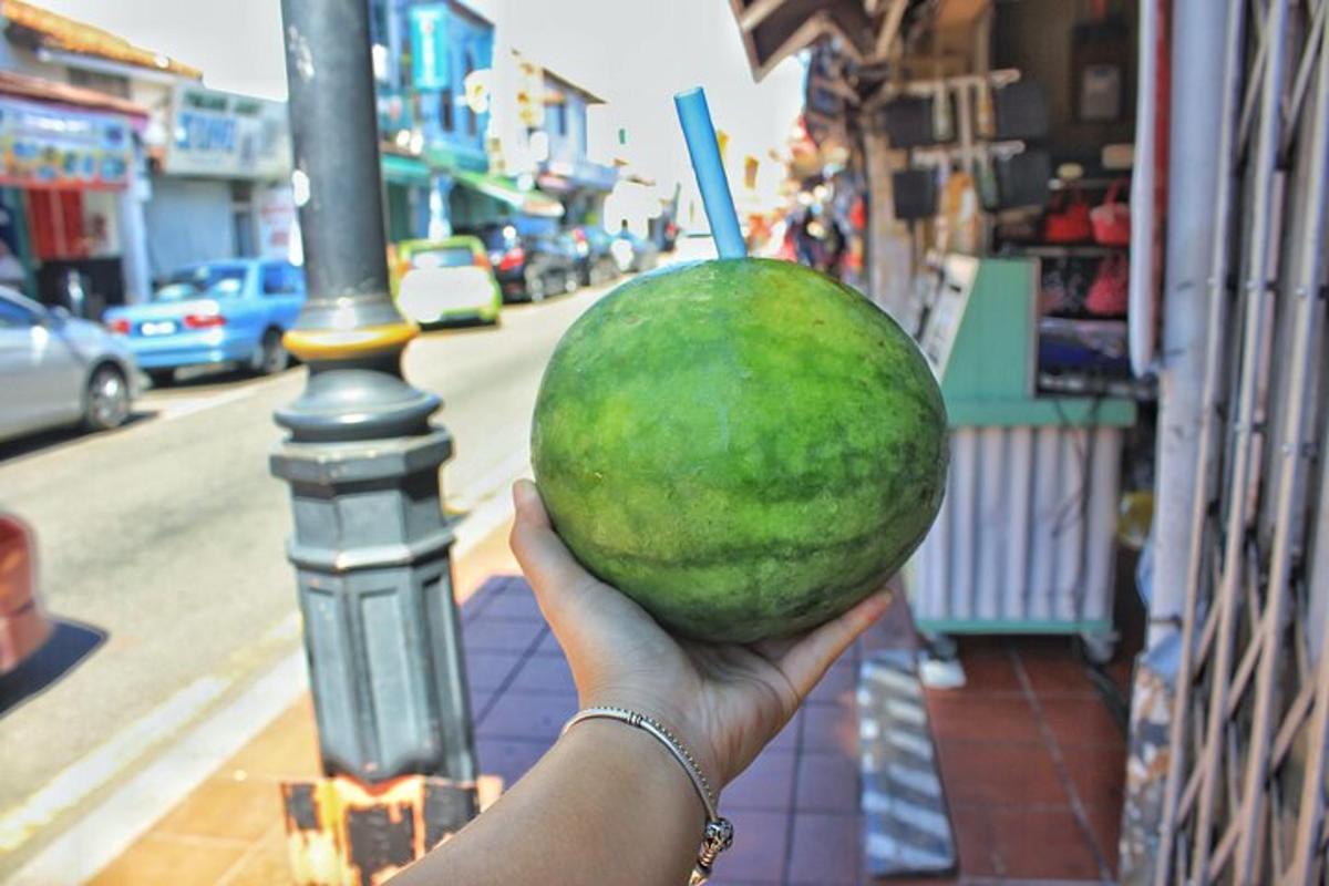 a person holding a green watermelon in their hand