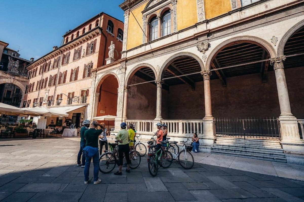 a group of people standing in front of a building with bikes