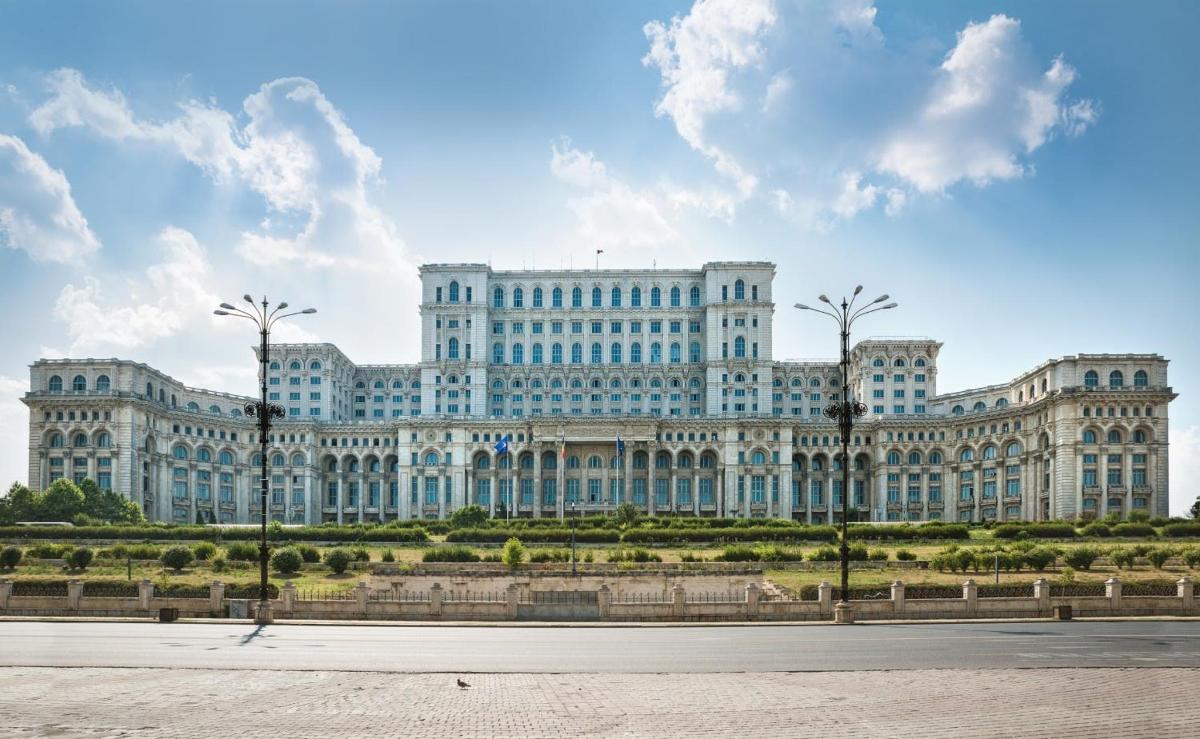 a large white building with palm trees in front of it