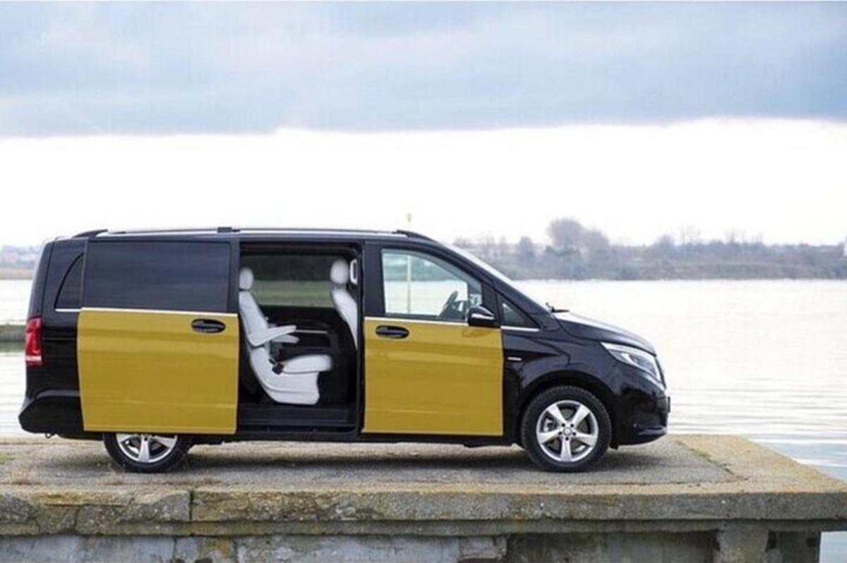 ein schwarz-gelber Lieferwagen, der neben einem Gewässer geparkt ist