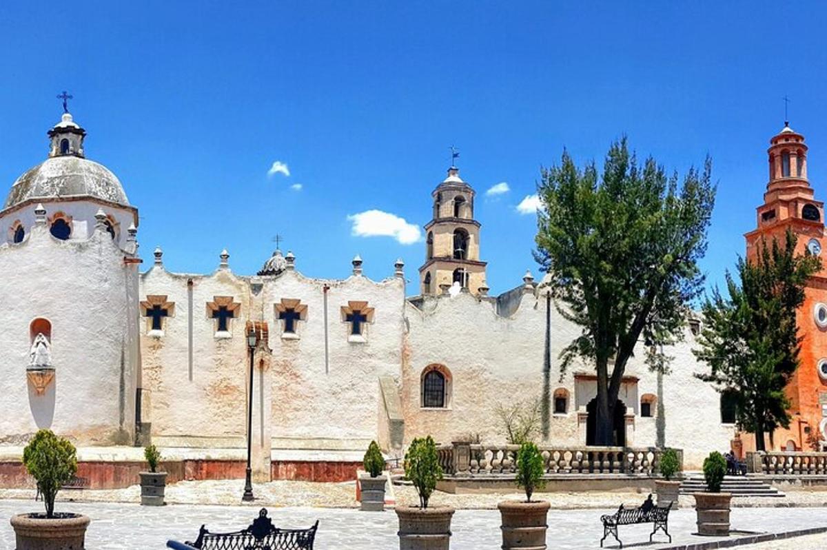 Un gran edificio blanco con dos torres y bancos.