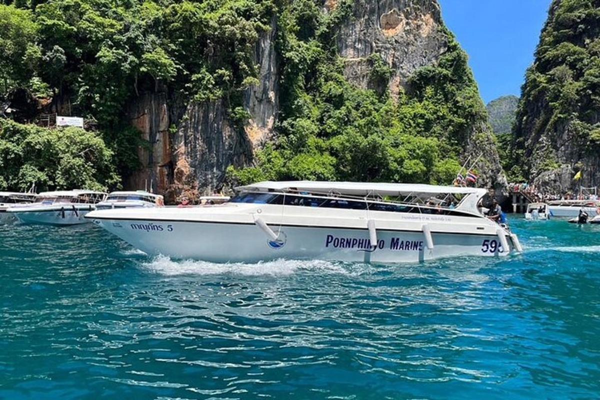 um barco branco na água perto de uma montanha