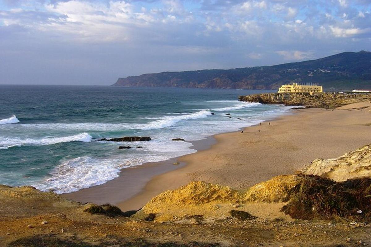 una platja amb l'oceà i un edifici a la distància