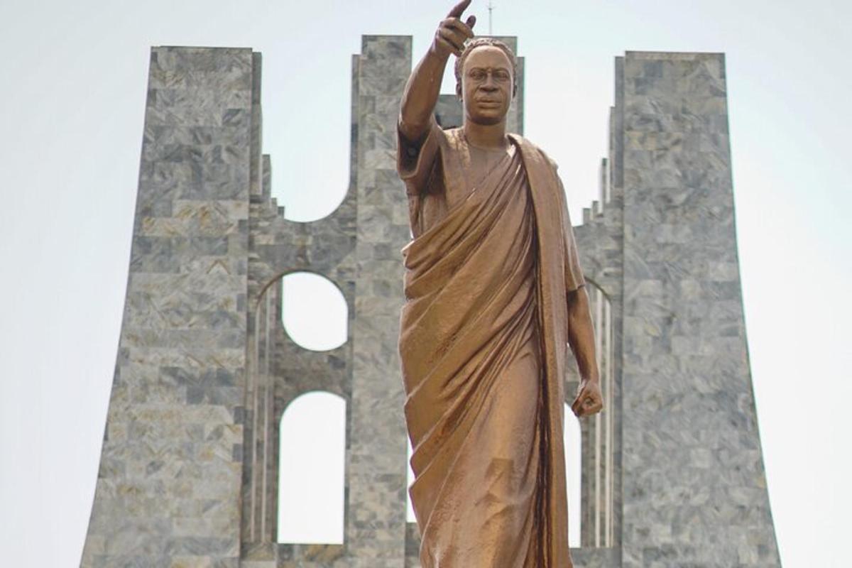 una statua di un uomo in piedi davanti a un monumento