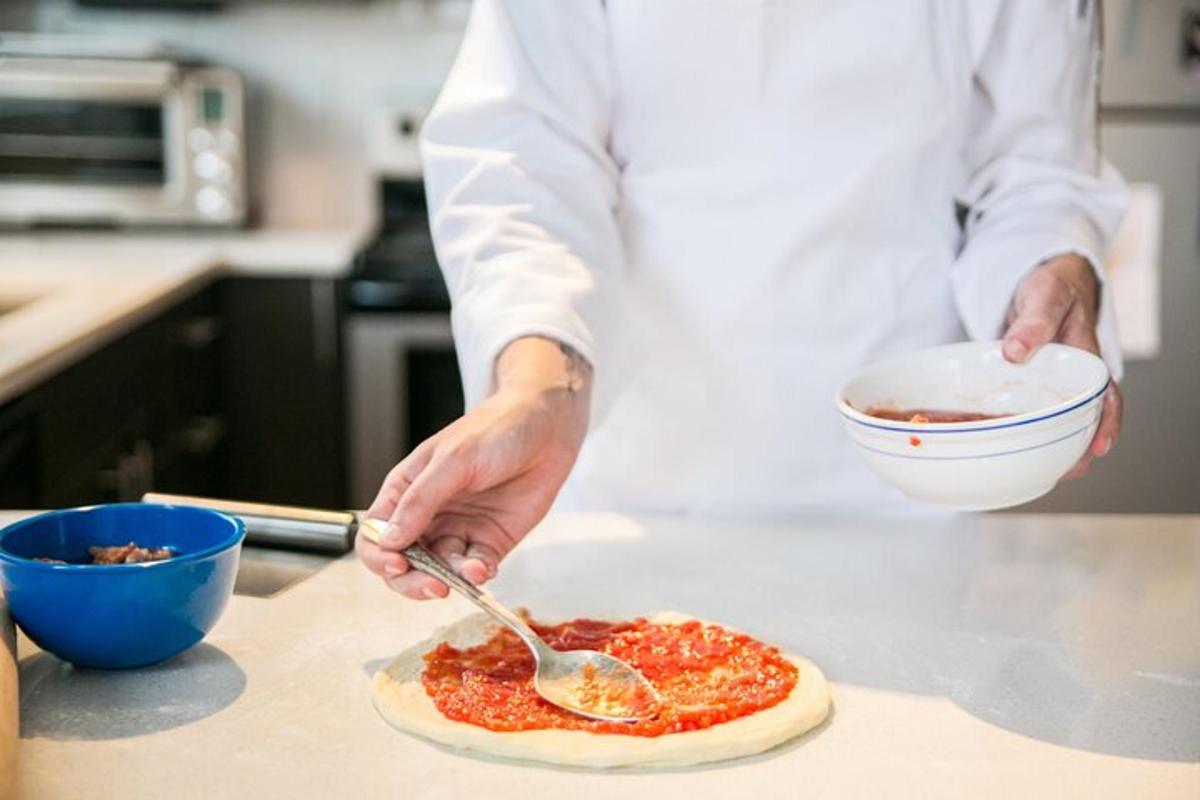 un uomo in cucina che prepara una pizza