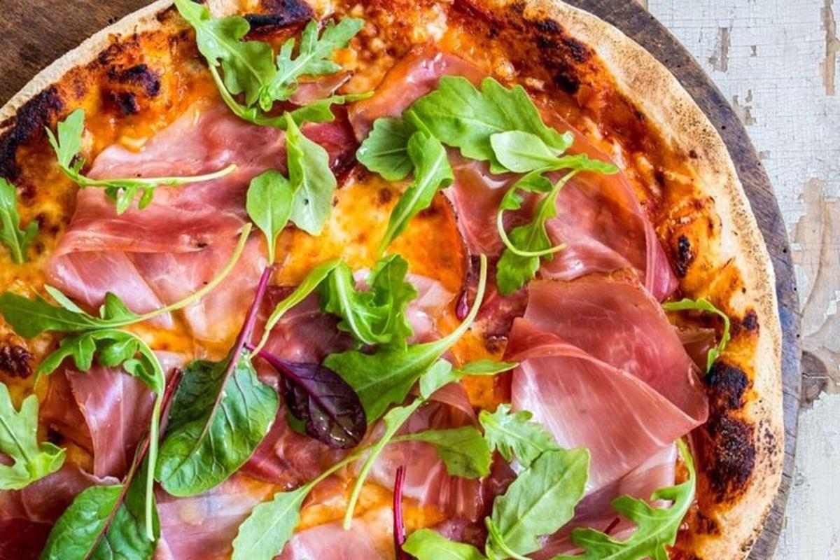 una pizza amb verdures a sobre sobre una taula