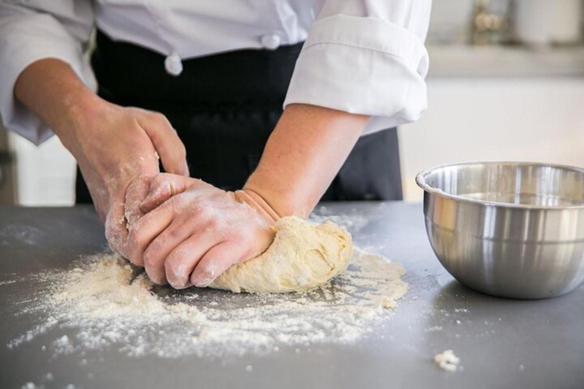 una persona sta impastando l'impasto su un bancone