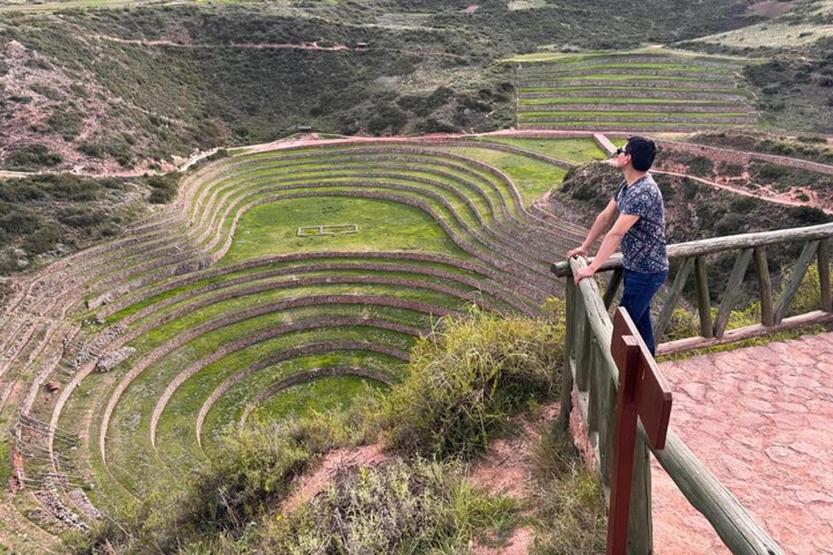 a man standing on a fence looking at an amphitheater