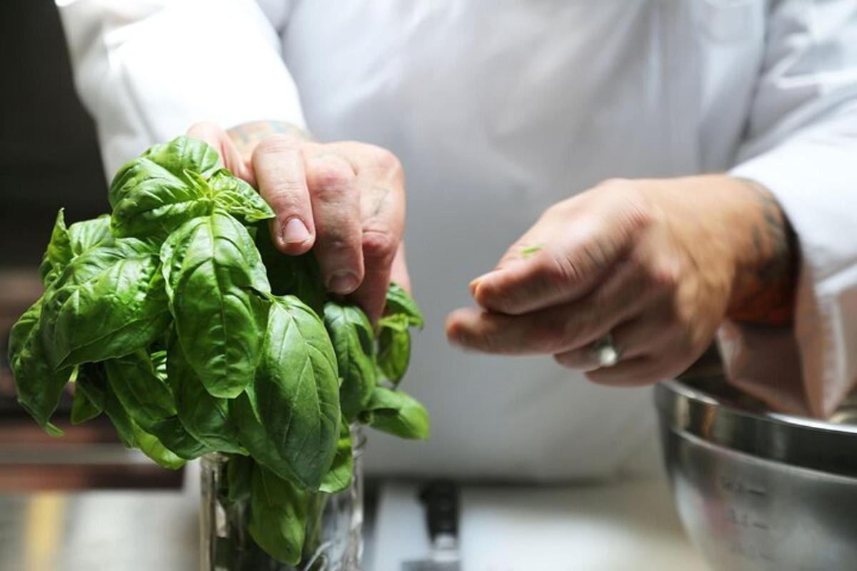 um chef está segurando um monte de espinafre verde