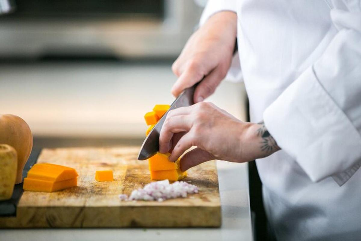 uno chef che taglia il formaggio su un tagliere