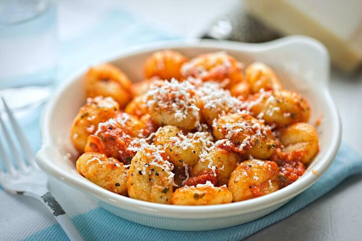 skál af pasta með osti á borði