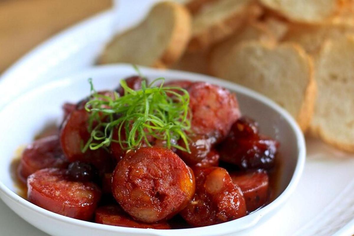 una ciotola bianca di cibo con polpette e pane