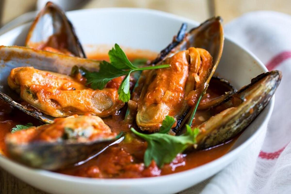una ciotola bianca di cibo con frutti di mare in salsa