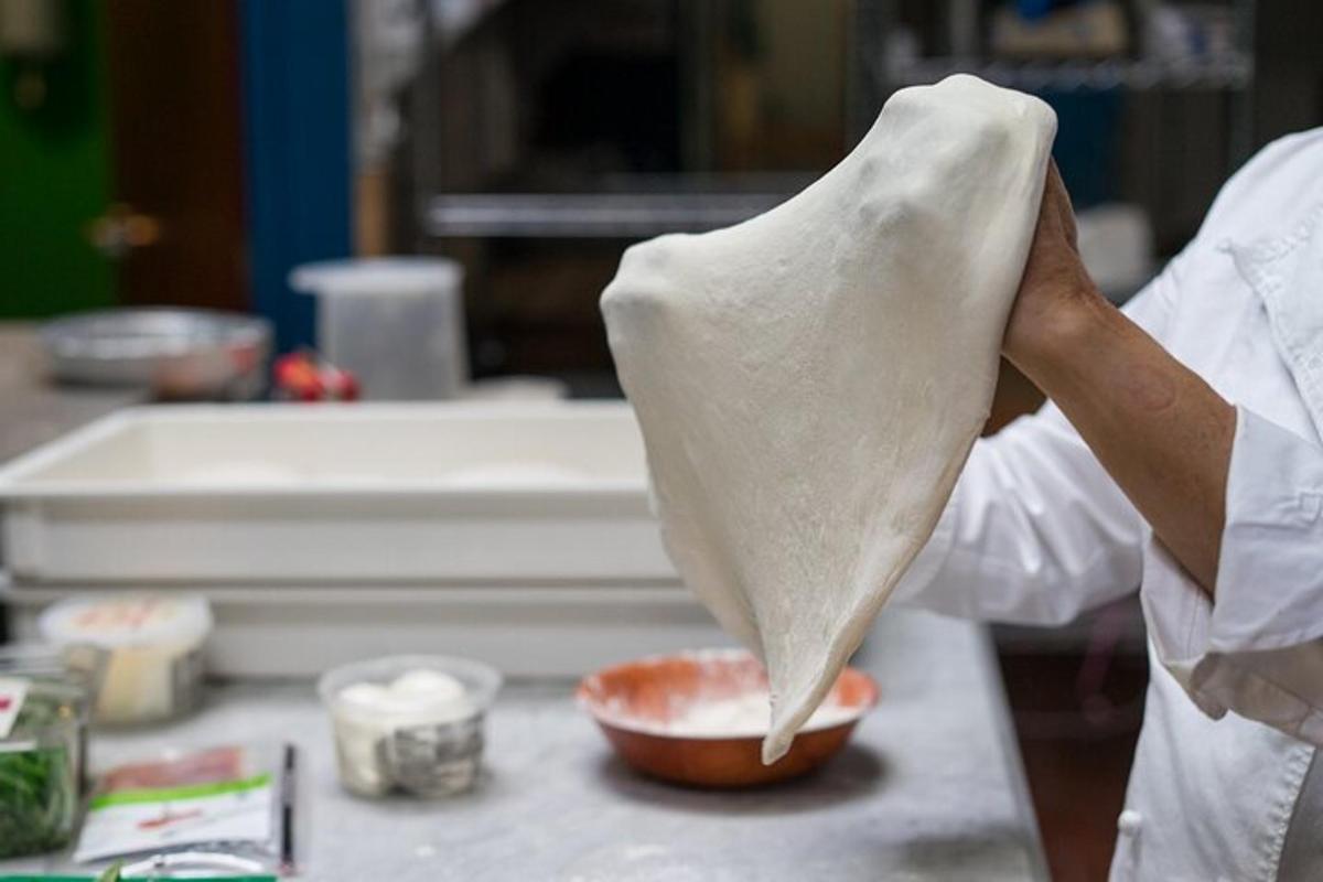 una persona che tiene in mano un pezzo di impasto in una ciotola