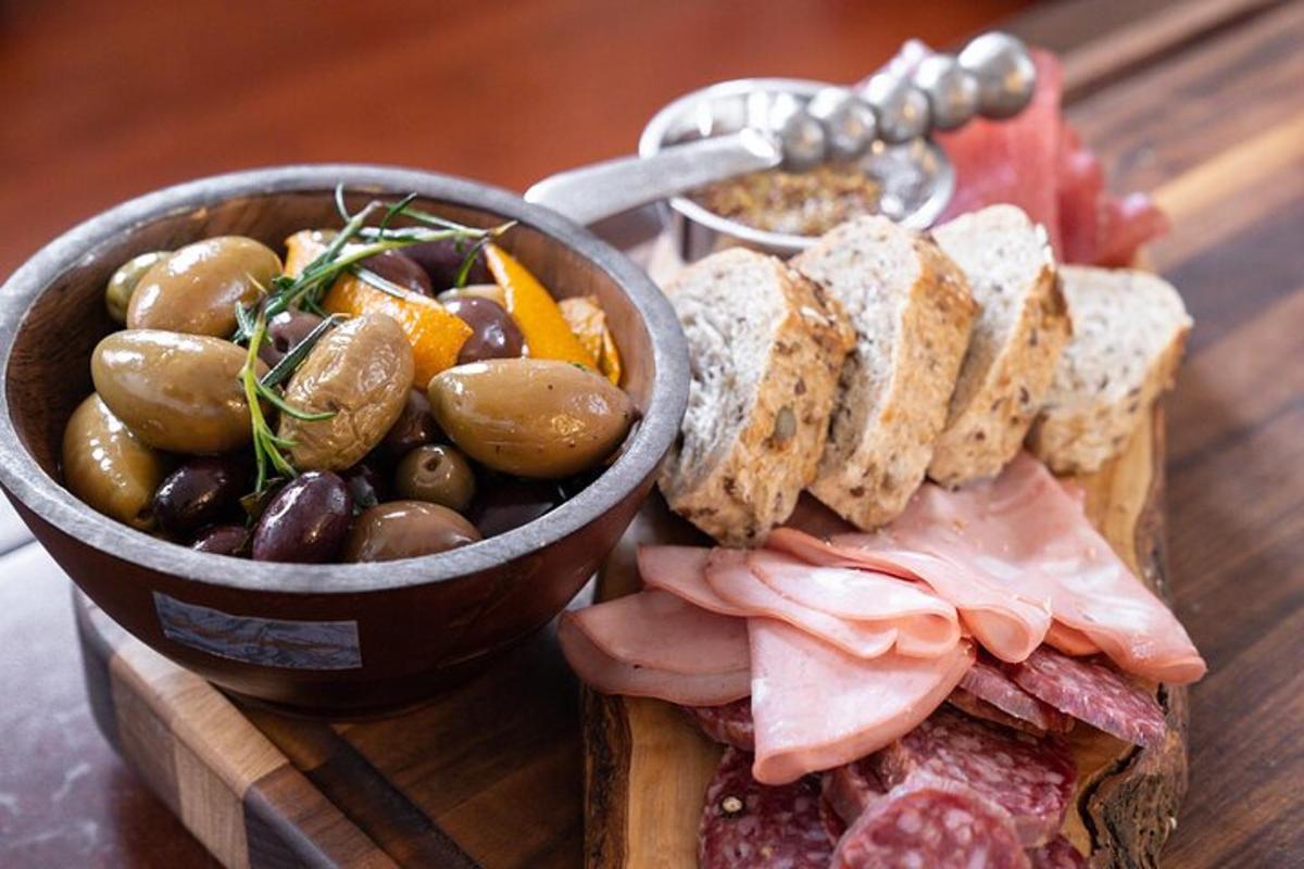 un piatto di cibo con un panino e una ciotola di olive