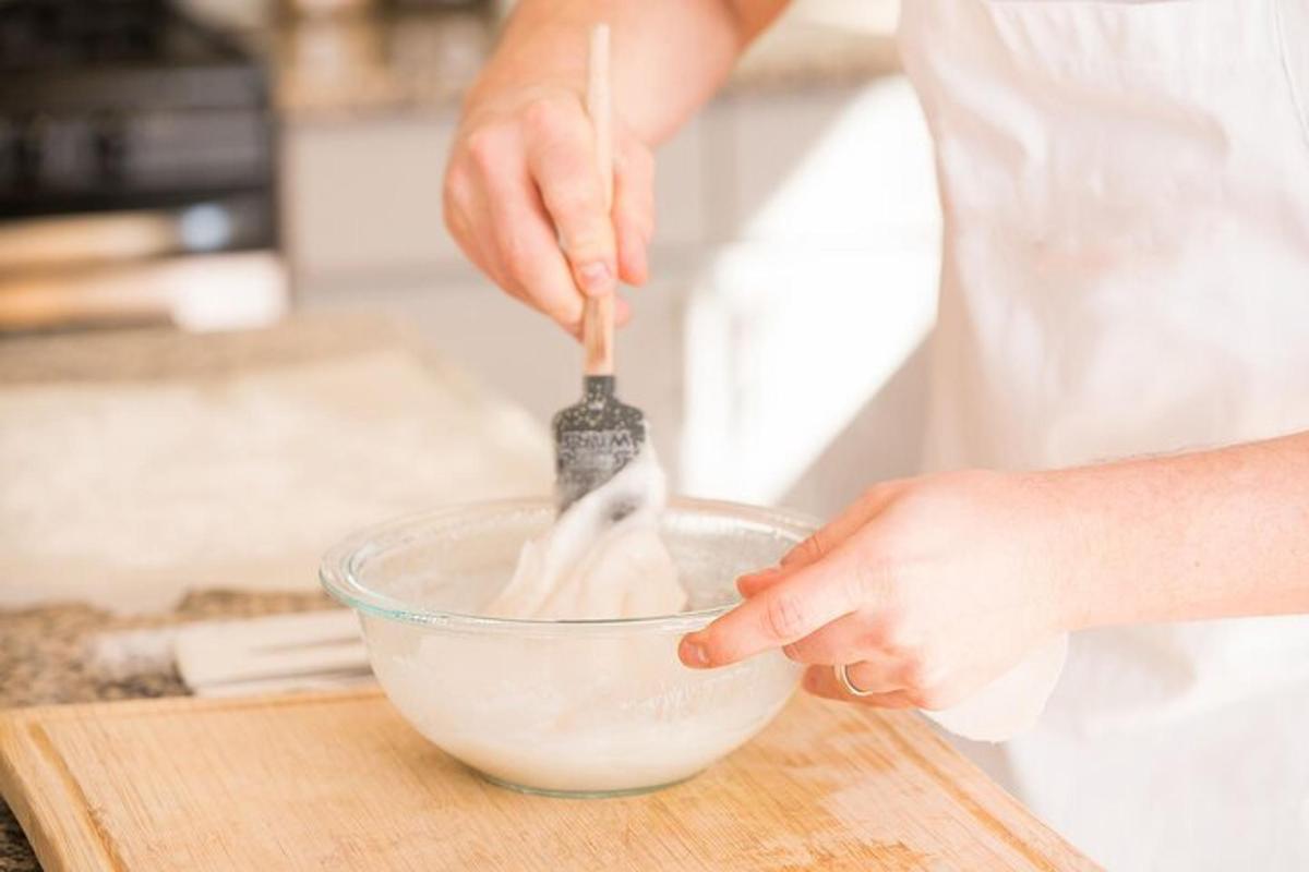 una persona che mescola gli ingredienti in una ciotola su un tagliere