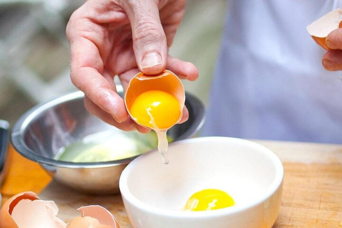 una persona tiene in mano un uovo in una ciotola