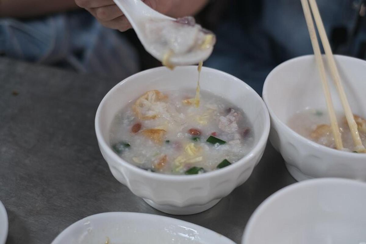 a person is eating a bowl of soup with chopsticks