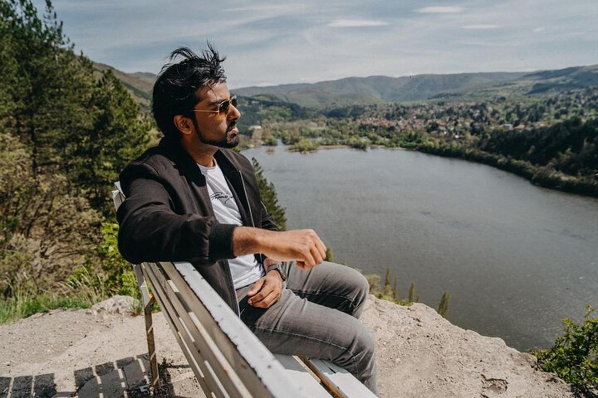 a man sitting on a bench overlooking a lake
