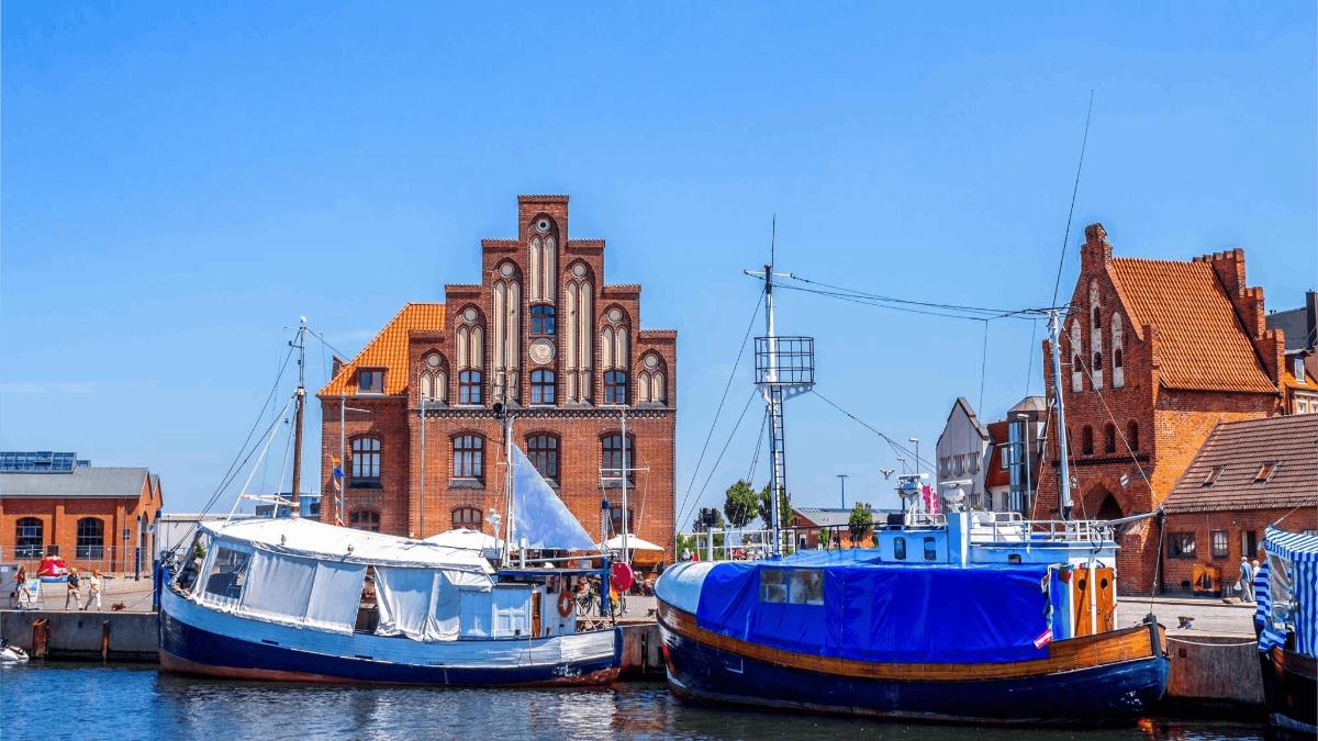 三艘船停靠在一栋建筑物前的港口