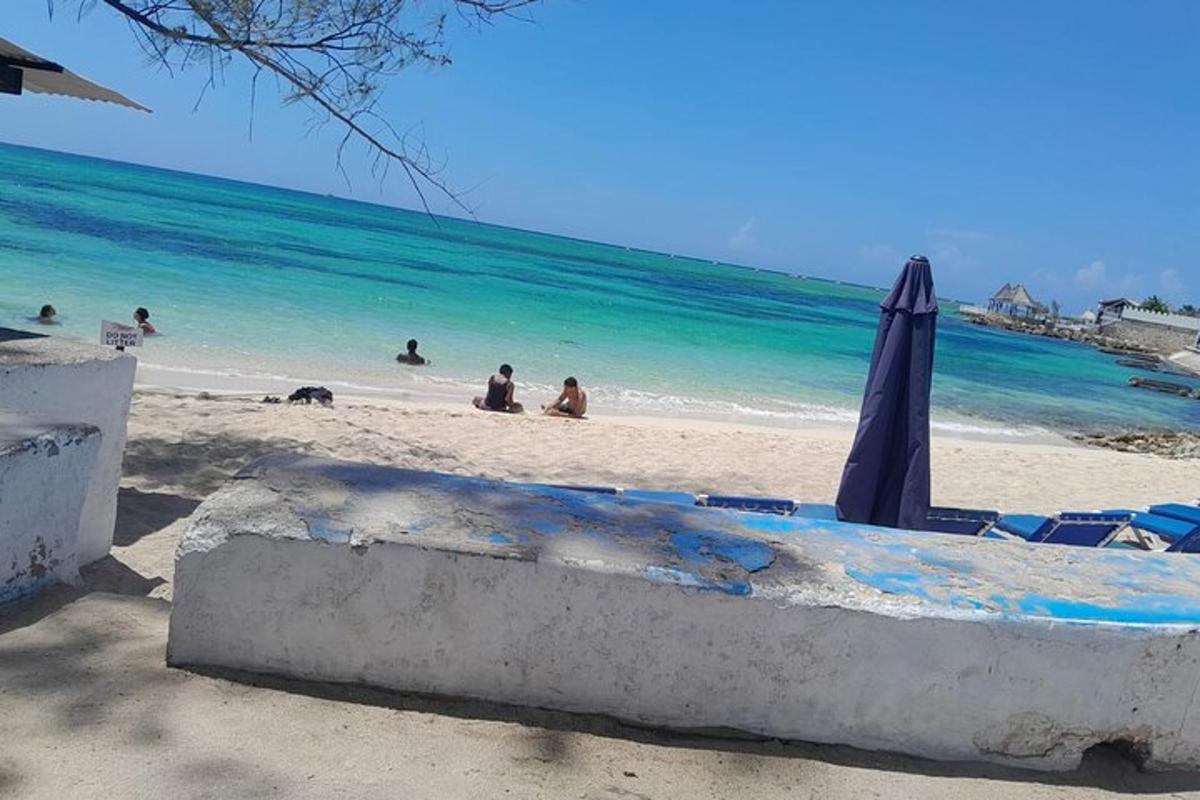 a beach with an umbrella and people on the beach