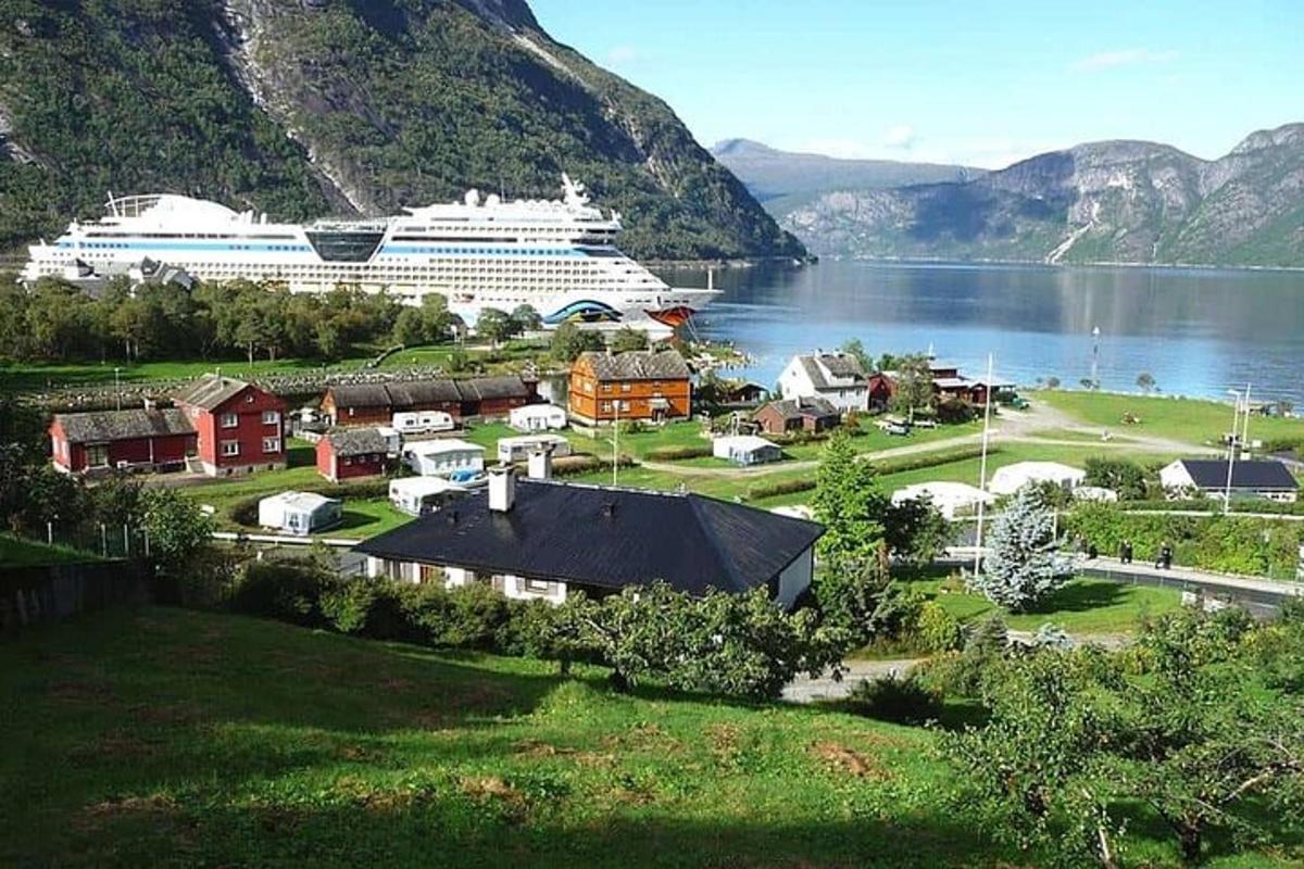 Ein Kreuzfahrtschiff liegt in einer kleinen Stadt am Wasser vor Anker