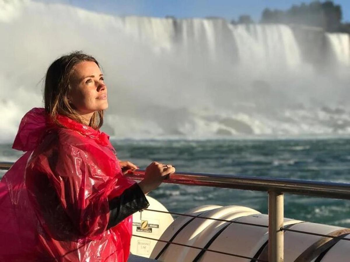 kona á bát fyrir framan foss