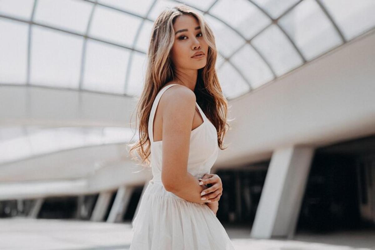 a woman in a white dress standing in a building