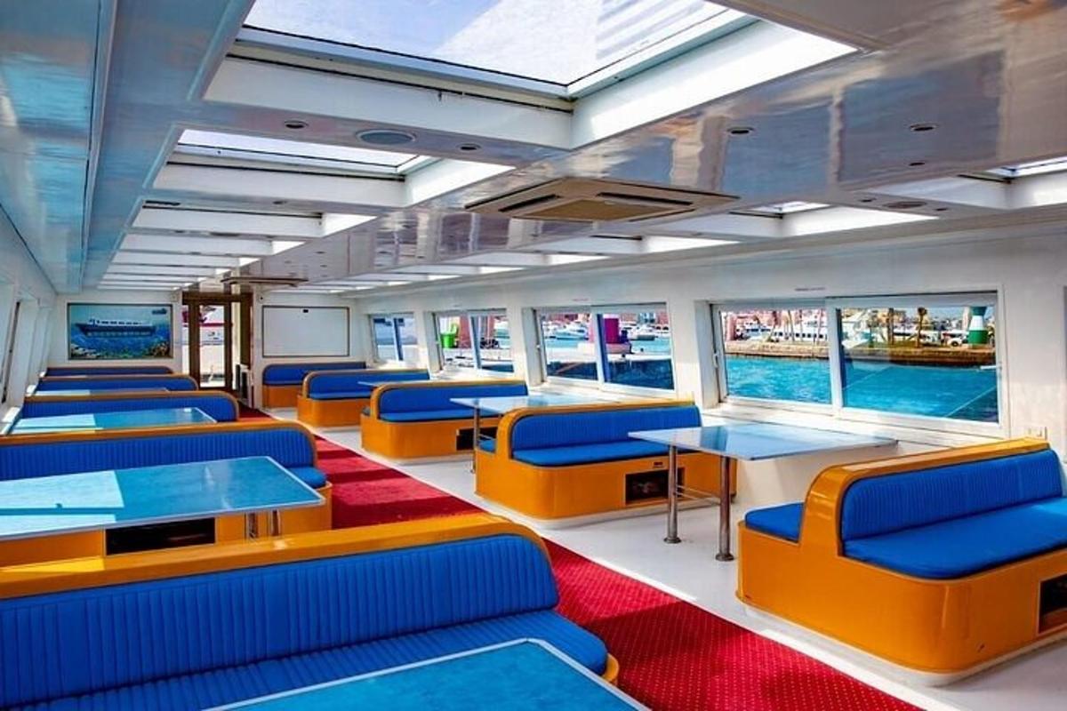 sebuah kereta api dengan kerusi dan meja berwarna biru dan oren