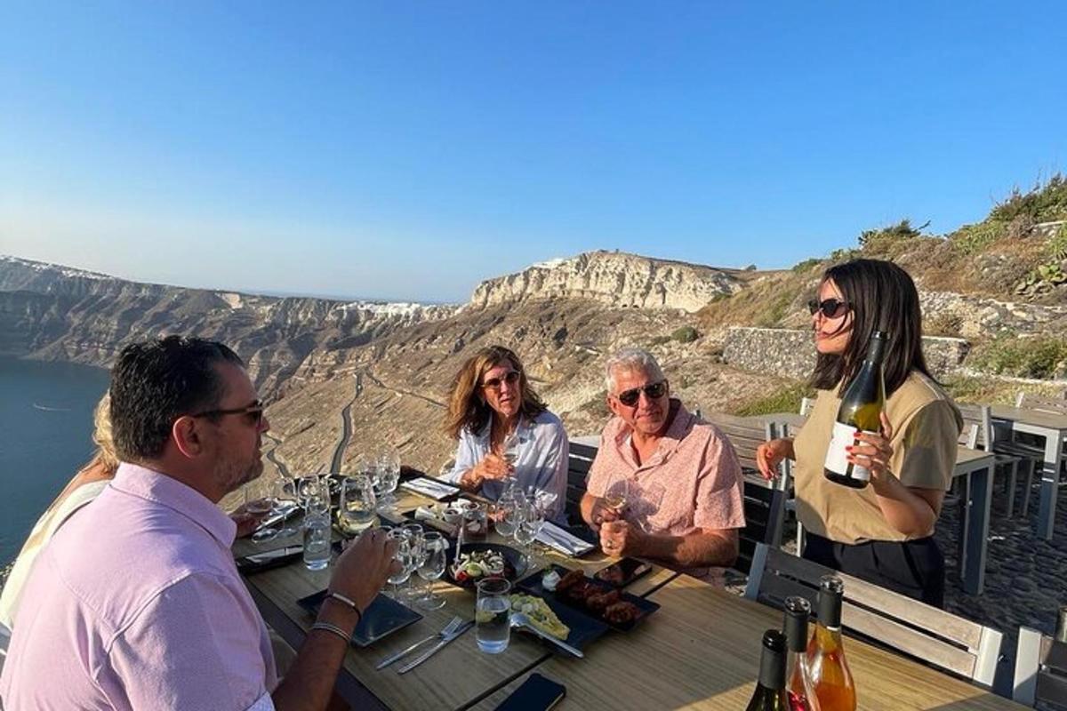 un gruppo di persone sedute a un tavolo con bicchieri di vino