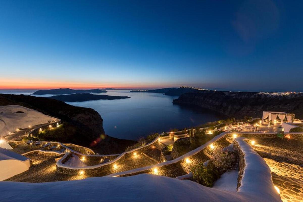 una vista notturna di un lago con luci su una montagna