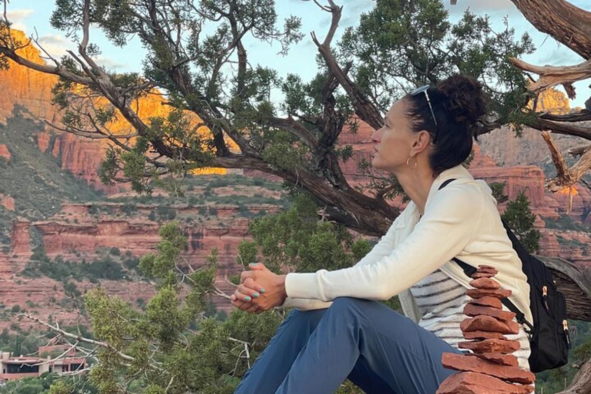 una donna seduta in cima a una parete rocciosa nel Grand Canyon