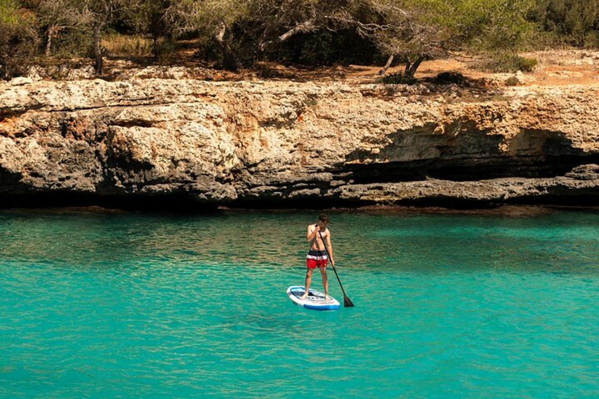 un uomo in piedi su una tavola da paddle in acqua