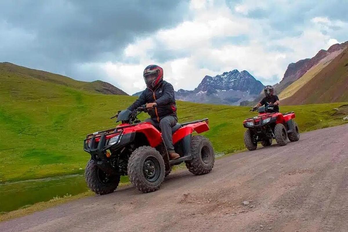 două persoane care călătoresc pe ATV-uri pe un drum de pământ