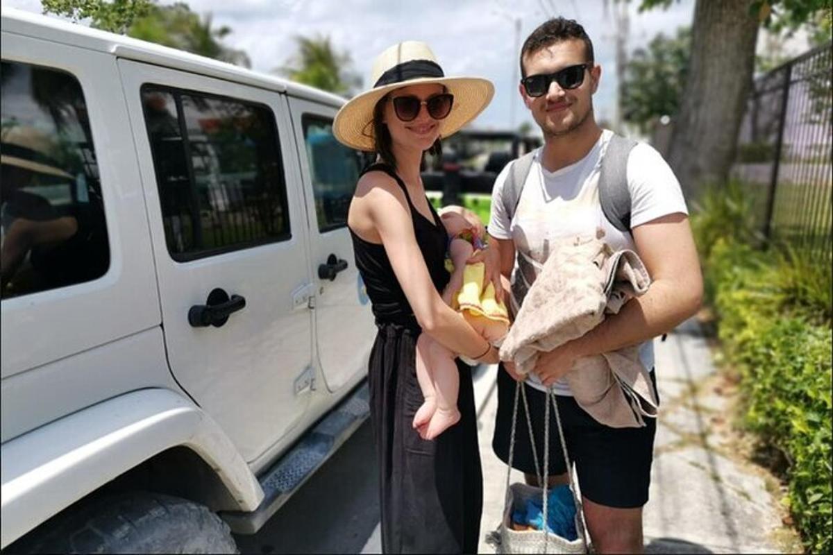 un home i una dona amb un nadó al costat d'una furgoneta