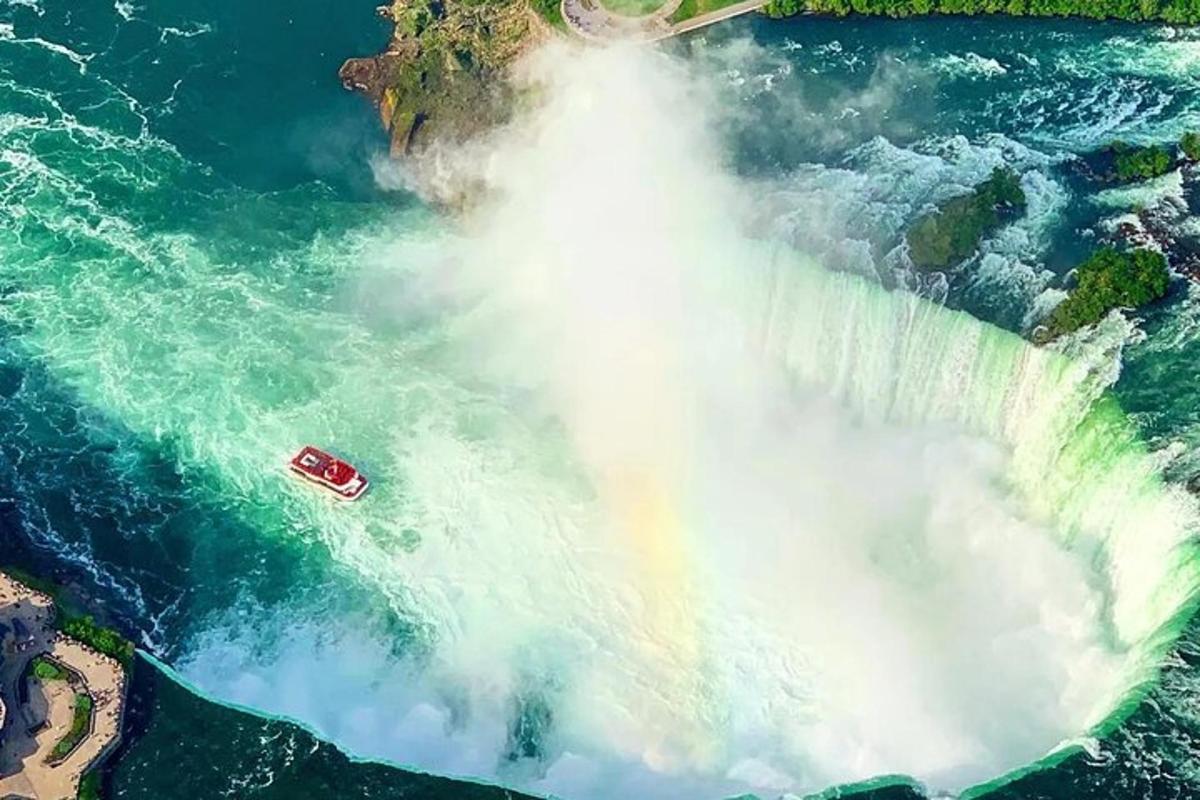 an aerial view of a waterfall with a boat in the water