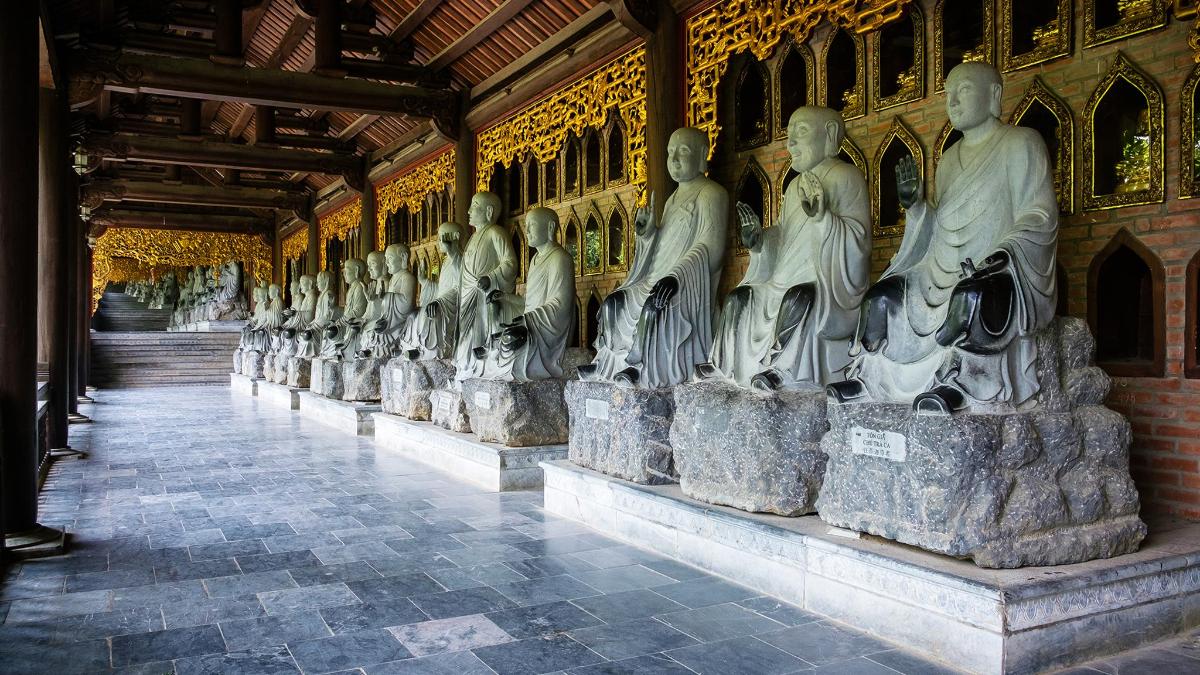 a row of statues of people in a building