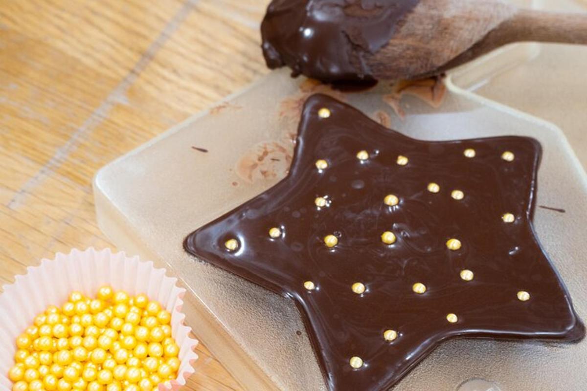 a star shaped cookie on a cutting board next to a cupcake
