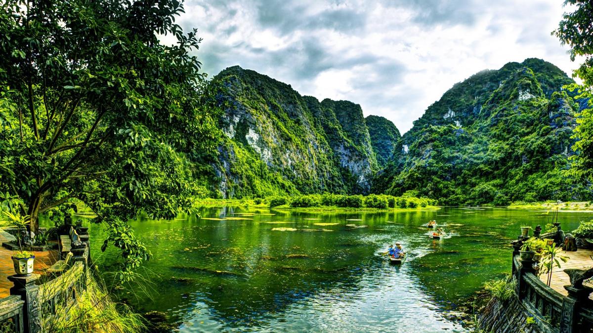 two people in boats in a river with mountains
