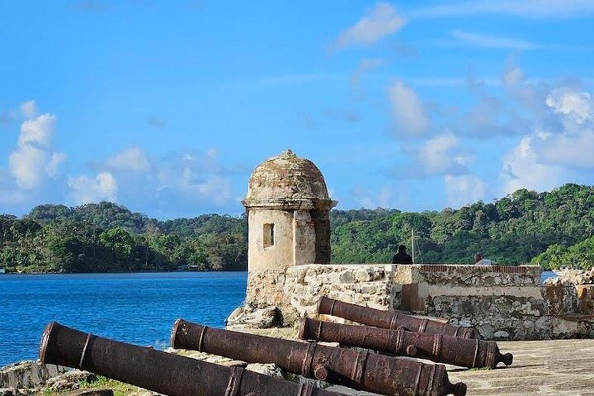 Un antiguo edificio de piedra junto a un cuerpo de agua.