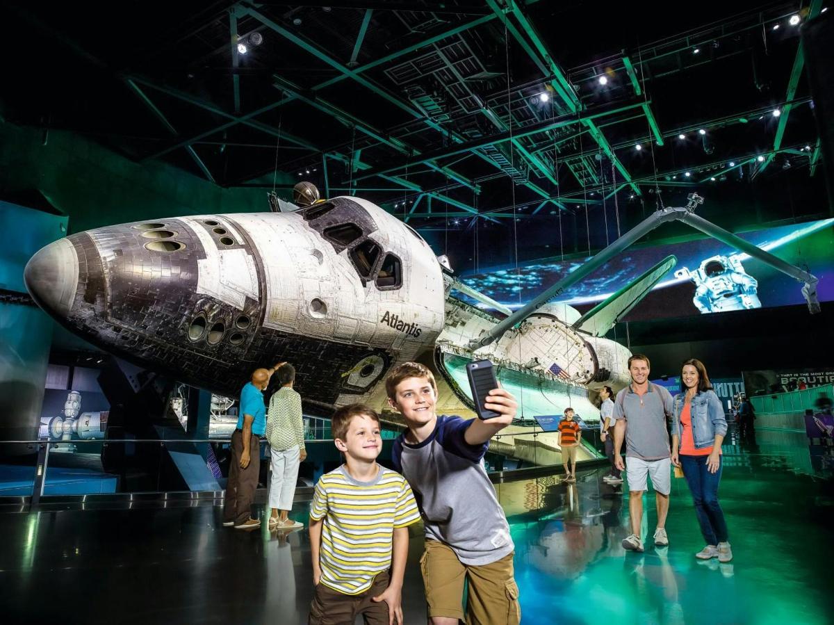skupina lidí stojících před raketoplánem