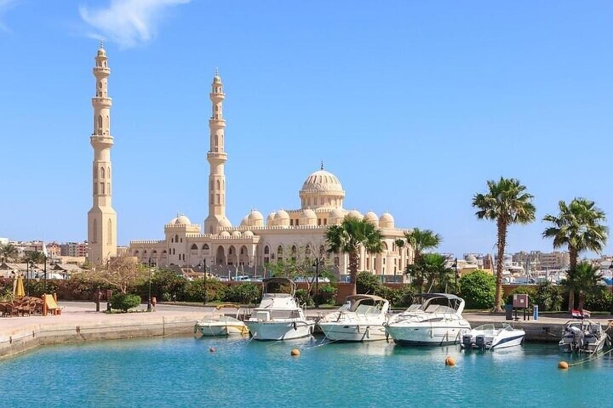 Una mezquita con barcos en el agua frente a ella.