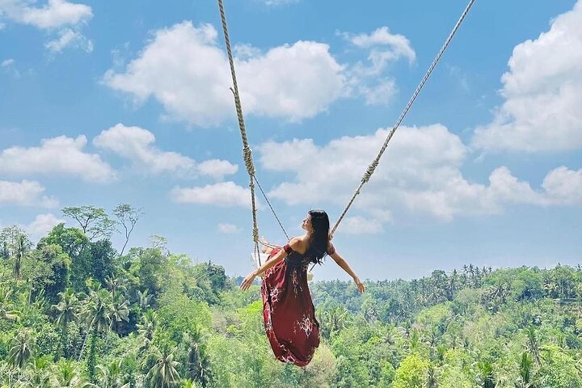 Una mujer con un vestido balanceándose en un columpio de cuerda