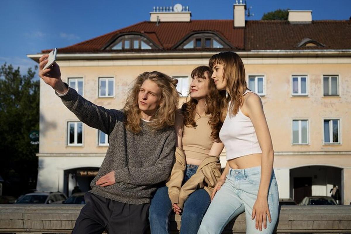 三个女孩坐在墙上用飞盘拍照