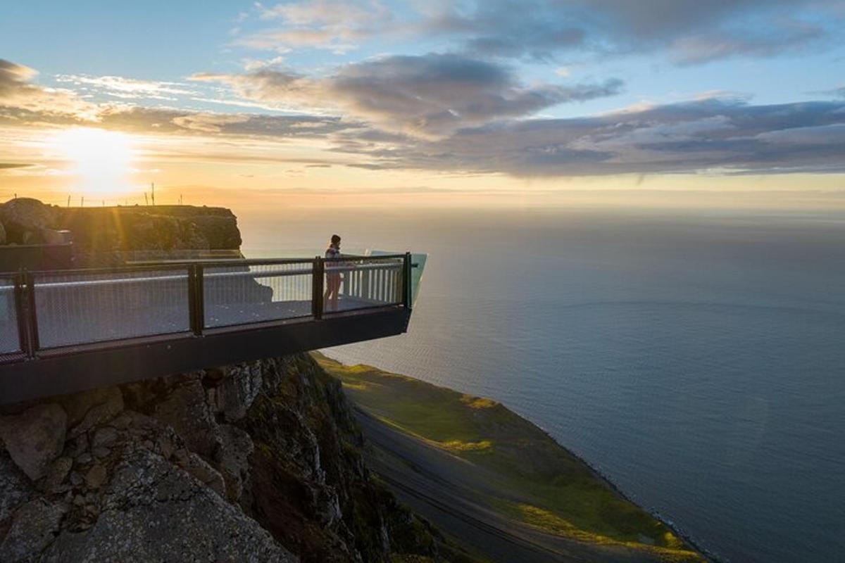 osoba stojící na mostě přes oceán