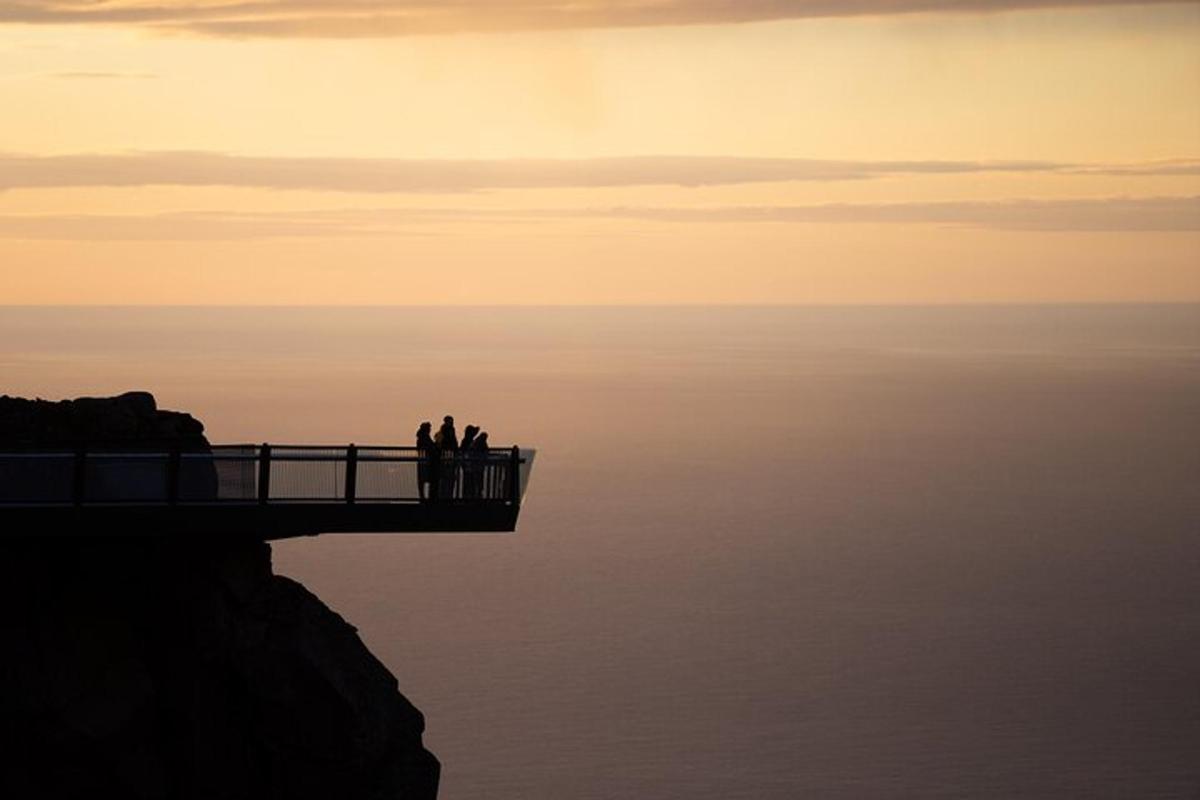 skupina lidí stojících na molu nad vodou